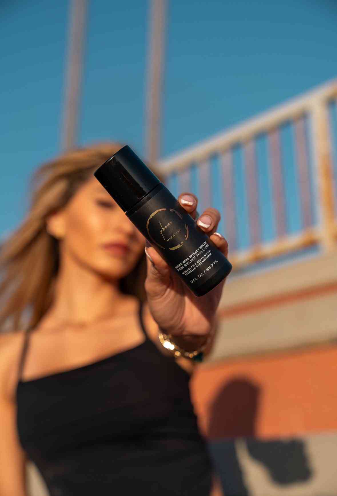 a person holding a muscle roll on gel from theme naturals cbd